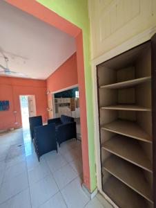 a living room with orange walls and a book shelf at El europeo in Santo Domingo +1 photo