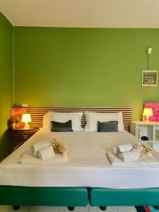a bedroom with a large bed with a green wall at Bnbook Villa Biancospino in Travedona
