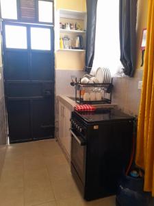 a kitchen with a stove and a black door at BnB in Homa Bay