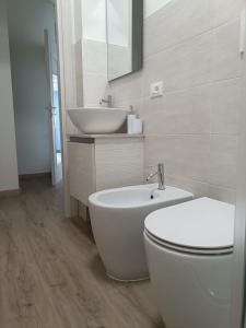 a white bathroom with a sink and a toilet at B&B Rita in Due Maestà