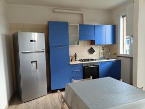 a kitchen with blue cabinets and a stainless steel refrigerator at B&B Rita in Due Maestà