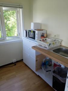 a kitchen with a counter with a microwave and a sink at tau bed and breakfast in Strand