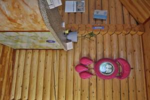 Draufsicht auf ein Holzgebäude mit einem Tisch und Blumen in der Unterkunft Argali hotel in Bügat