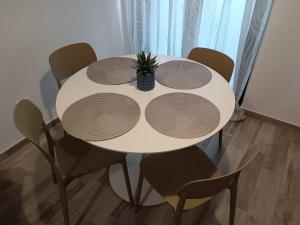 a white table with chairs and a pineapple on it at La Maison de Roland in Pescara +4 photos
