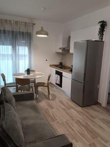 a kitchen with a table and a refrigerator in a room at La Maison de Roland in Pescara