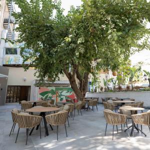 a group of tables and chairs under a tree at Royal Court Hotel in Ramallah