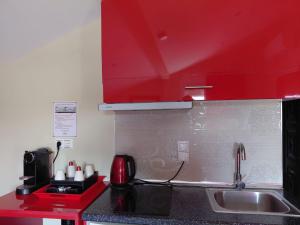 a kitchen with a sink and a red cabinet at Apartments Vesna Luxury & Stefan ap 4 in Paralia Katerinis +28 photos