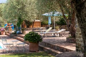 a patio with chairs and a table and umbrella at Agriturismo Il Vecchio Casale in Vatolla