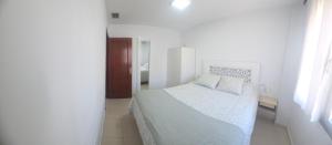 a small white bedroom with a bed and a window at Casa Andrea in Puerto Real