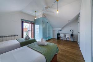 a room with two beds and a table with chairs at BeSmart Suites with Private WC by Home Sweet Home Aveiro in Aveiro +69 photos