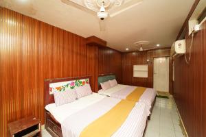 two beds in a room with wood paneling at Udhaya Lodge in Rāmeswaram