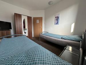 a hotel room with two beds and a tv at Gästehaus Vienenburg - Monteurzimmer in Goslar
