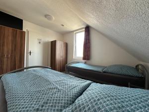 a bedroom with two beds and a window at Gästehaus Vienenburg - Monteurzimmer in Goslar +3 photos