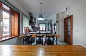 a kitchen with a wooden table and chairs at BeSmart Suites with Private WC by Home Sweet Home Aveiro in Aveiro