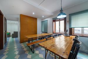 a conference room with wooden tables and chairs at BeSmart Suites with Private WC by Home Sweet Home Aveiro in Aveiro