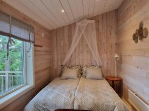 a bedroom with a bed with a canopy at Forest Lodge Ryokan in Trosa