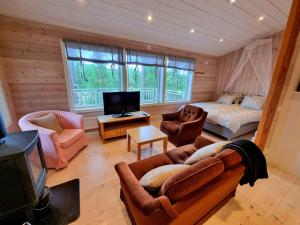 a living room with a couch and a bed and a tv at Forest Lodge Ryokan in Trosa