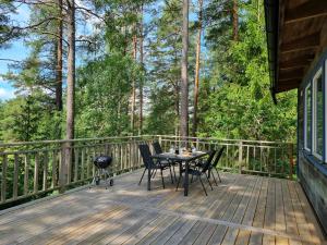 a wooden deck with a table and chairs on it at Forest Lodge Ryokan in Trosa +24 photos