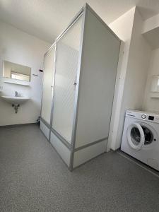 a bathroom with a washing machine and a washer at Gästehaus Vienenburg - Monteurzimmer in Goslar