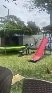a playground with a red slide and a green slide at Sombra de Macaneta in Marracuene