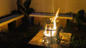 a fire burns in front of a bench at Sombra de Macaneta in Marracuene