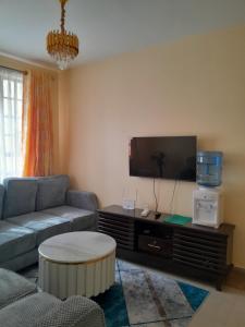 a living room with a couch and a flat screen tv at BnB in Homa Bay