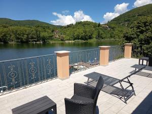 a patio with a table and chairs and a view of a lake at Setteacque Lakeview Rooms in Piediluco