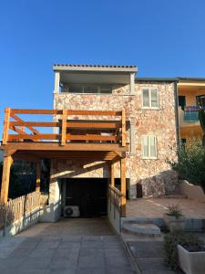 a house with a wooden deck in front of it at Dimora Vicky - La Ciaccia in Valledoria