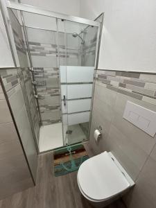 a bathroom with a toilet and a glass shower at Dimora Vicky - La Ciaccia in Valledoria