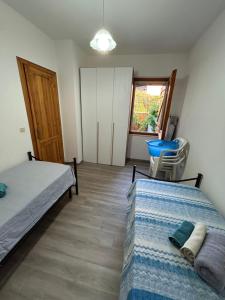 a bedroom with two beds and a chair in it at Dimora Vicky - La Ciaccia in Valledoria