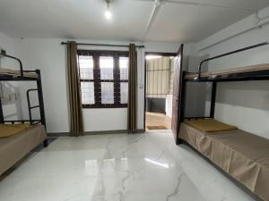 a room with two bunk beds and a doorway at Sleek Haven Dormitory in Meppādi
