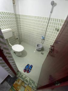 a bathroom with a toilet and two slippers at Sleek Haven Dormitory in Meppādi +5 photos