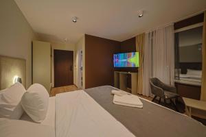 a hotel room with a bed and a television at Hotel Impex in Peje
