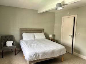 a bedroom with a white bed and a chair at The Gate House in Galway