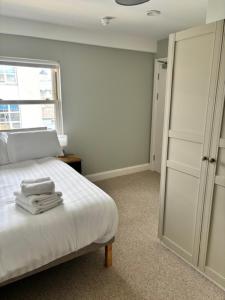 a bedroom with a white bed and a window at The Gate House in Galway +3 photos