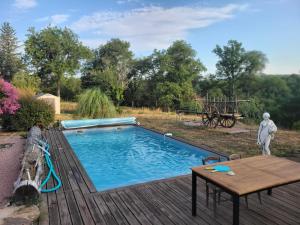 a swimming pool on a wooden deck with a table and a table at Roulotte à figeac in Figeac
