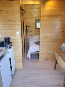 a bedroom in a log cabin with a bed in it at Roulotte à figeac in Figeac +5 photos