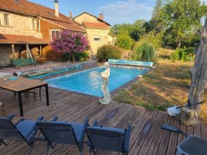 a woman standing on a deck next to a swimming pool at Roulotte à figeac in Figeac
