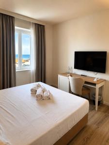 a hotel room with a bed and a desk and a television at PFA Hotel - Viareggio in Viareggio