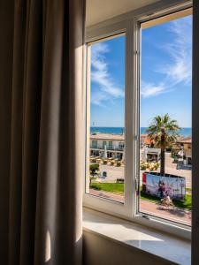 a room with a window with a view of the ocean at PFA Hotel - Viareggio in Viareggio