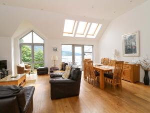 a living room with a table and a dining room at Craigard in Aberfeldy