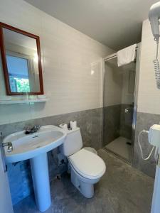 a bathroom with a toilet and a sink and a shower at CASA LAS OLAS DE LANGRE in Langre