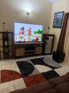 a living room with a flat screen tv with children on it at Bella Casa in Kingstown