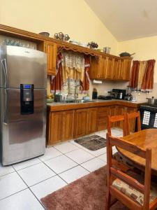 a kitchen with a stainless steel refrigerator and wooden cabinets at Bella Casa in Kingstown