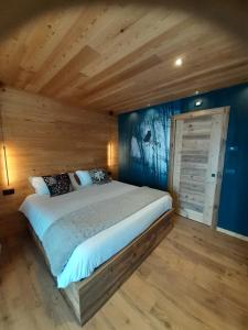 a bedroom with a large bed and a wooden wall at Affittacamere Sbulìa in Santo Stefano di Cadore