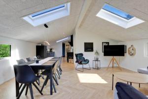 a living room with a table and chairs and skylights at JB415-Fjerritslev-Ahornvej-18 in Fjerritslev