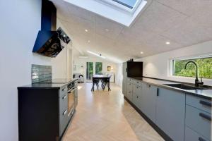 a kitchen with a skylight and a dining room with a table at JB415-Fjerritslev-Ahornvej-18 in Fjerritslev