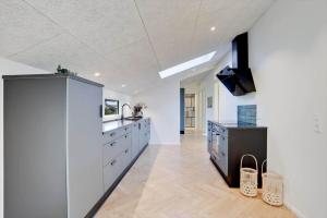 a large kitchen with white cabinets and a sink at JB415-Fjerritslev-Ahornvej-18 in Fjerritslev +11 photos