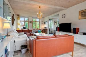 a living room with leather furniture and a tv at 4025-Borre-Liselundvej-20 in Borre