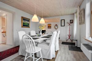a dining room with a white table and white chairs at 4025-Borre-Liselundvej-20 in Borre